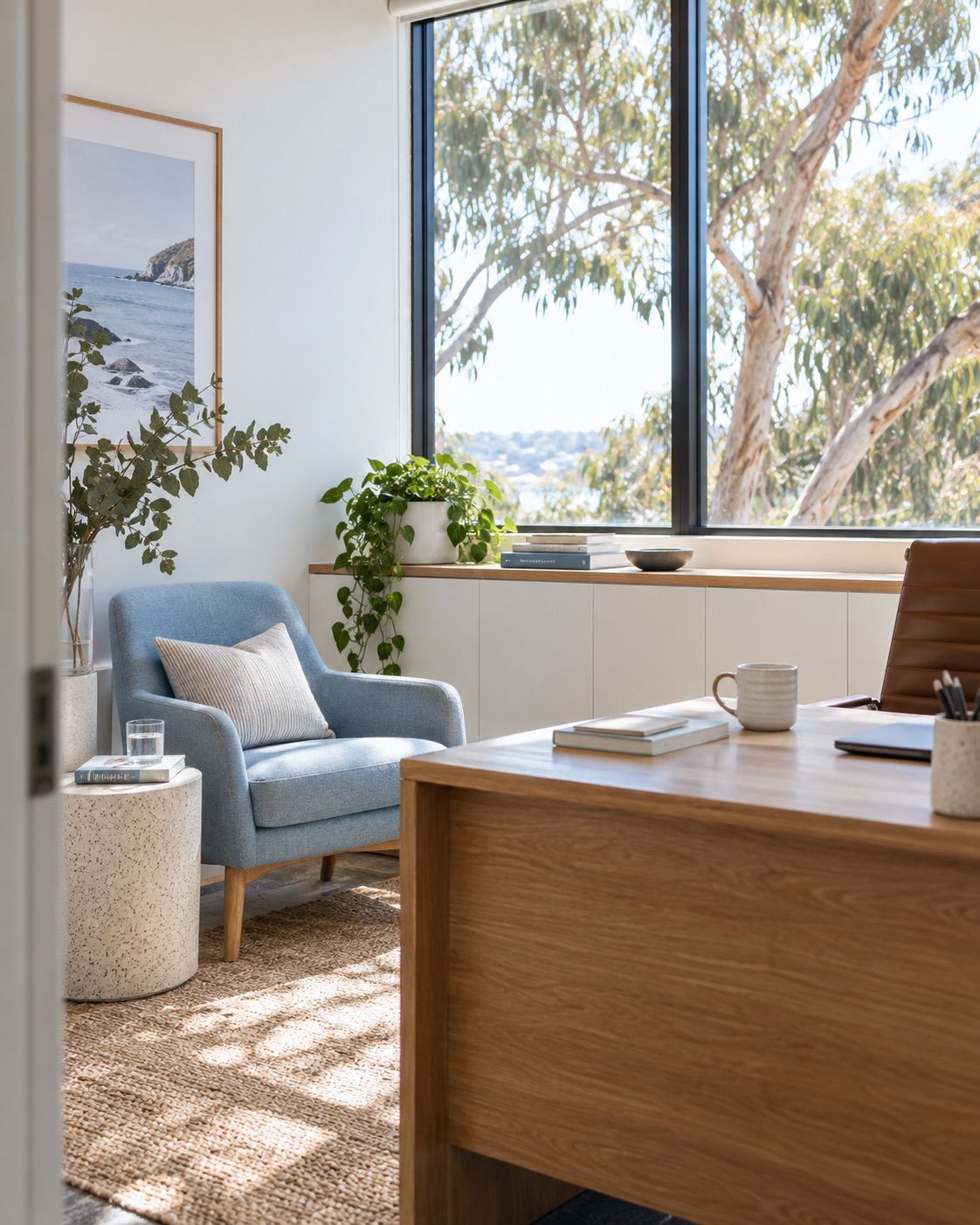 Sunlit office with a timber desk and pale blue guest chair